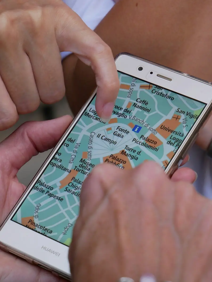 Due mani sul telefono con la mappa del centro di Siena